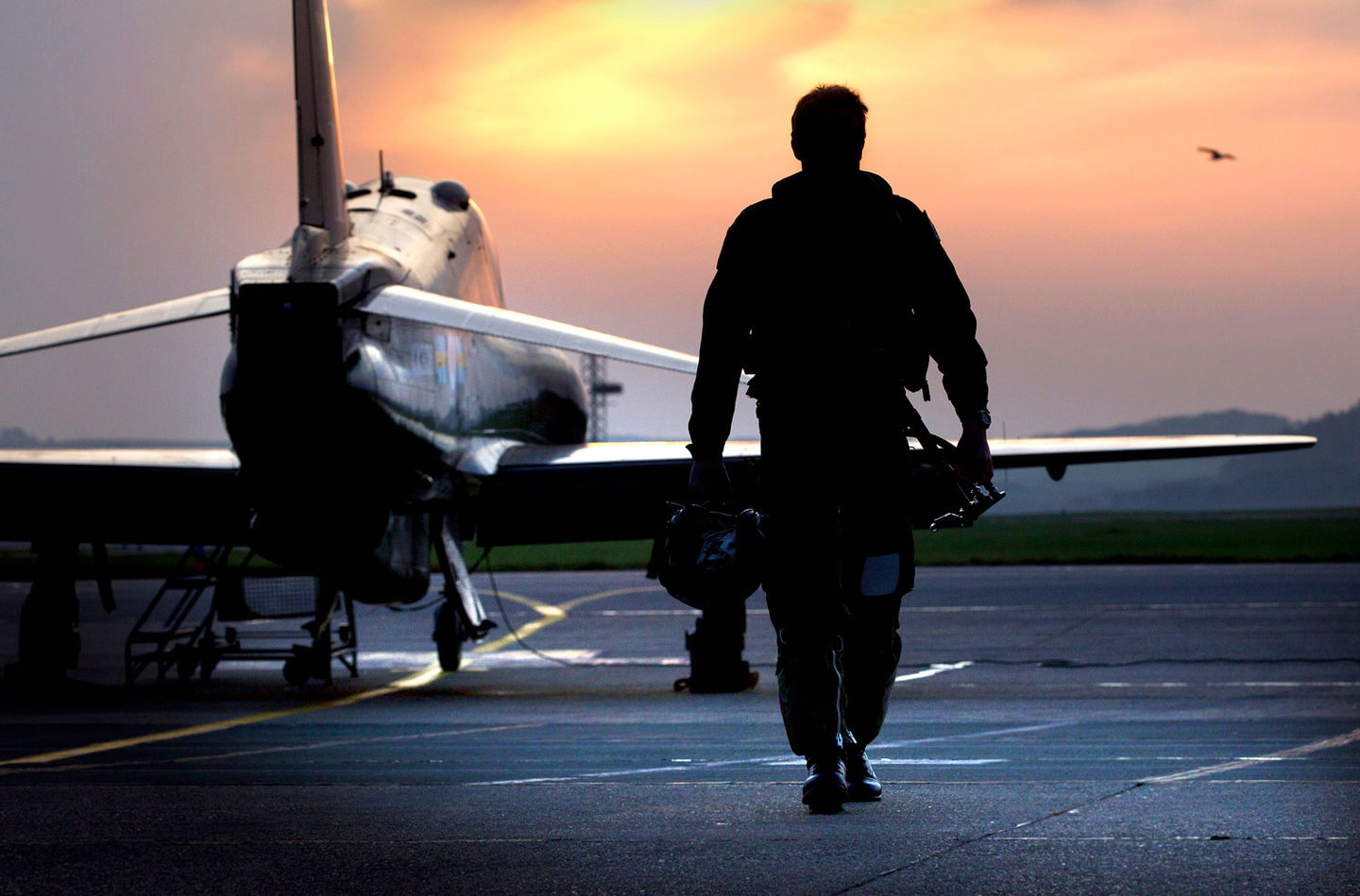 An RAF pilot approaches a Hawk training aircraft. 